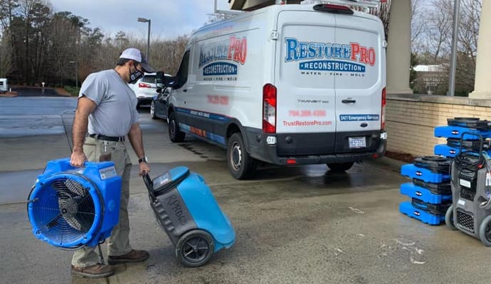 RestorePro Reconstruction professional with water damage restoration equipments